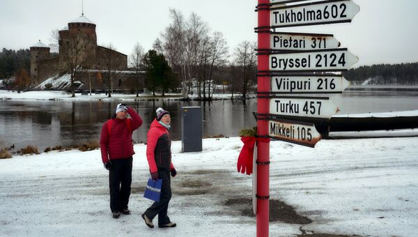 Туристы неподалеку от шведского замка Олавенлинна в городе Савонлинна Туристы неподалеку от шведского замка Олавенлинна в городе Савонлинна