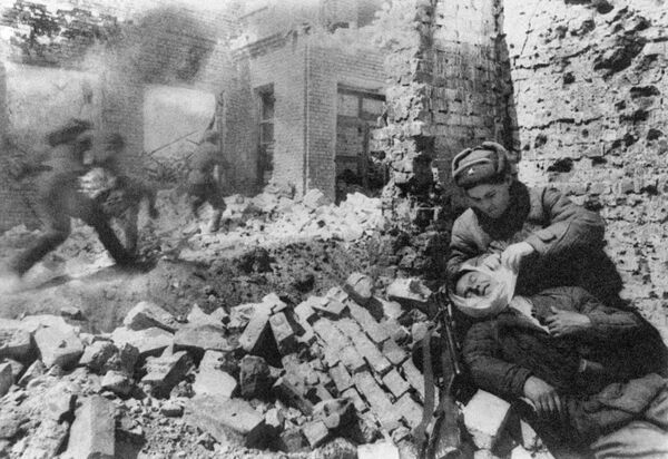 Сталинград. Декабрь 1942 г. Уличный бой. Санитарка перевязывает раненого Сталинград. Декабрь 1942 г. Уличный бой. Санитарка перевязывает раненого