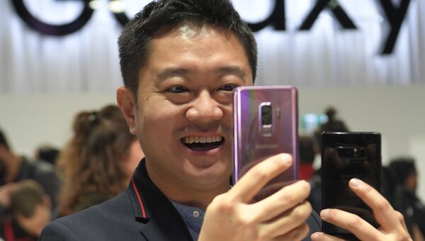 Мужчина держит новый Samsung Galaxy S9 на мероприятии Samsung Galaxy Unpacked 2018 в Барселоне, Испания. 25 февраля 2018 года Мужчина держит новый Samsung Galaxy S9 на мероприятии Samsung Galaxy Unpacked 2018 в Барселоне, Испания. 25 февраля 2018 года