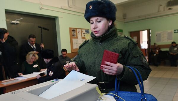 Женщина опускает бюллетень в урну на выборах президента РФ на избирательном участке №76 в Москве. 18 марта 2018 Женщина опускает бюллетень в урну на выборах президента РФ на избирательном участке №76 в Москве. 18 марта 2018