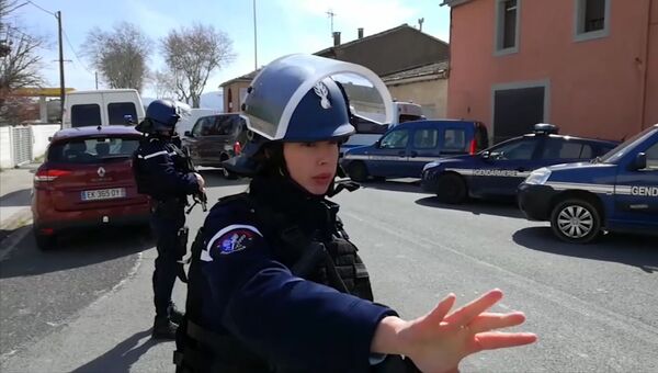 Сотрудники правоохранительных органов в коммуне Треб на юге Франции, где произошел захват заложников. 23 марта 2018 Сотрудники правоохранительных органов в коммуне Треб на юге Франции, где произошел захват заложников. 23 марта 2018