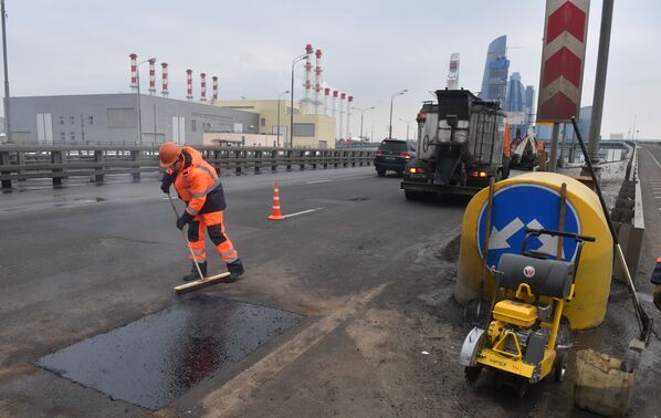 Рабочие ремонтируют участок дороги в Москве