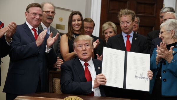 Президент США Дональд Трамп с подписанным указом, который сворачивает Obamacare, США. 12 октября 2017 Президент США Дональд Трамп с подписанным указом, который сворачивает Obamacare, США. 12 октября 2017