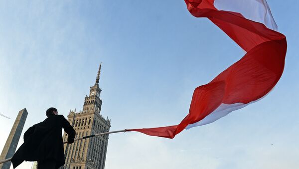 Мужчина держит польский флаг во время празднования Дня независимости в Варшаве Мужчина держит польский флаг во время празднования Дня независимости в Варшаве