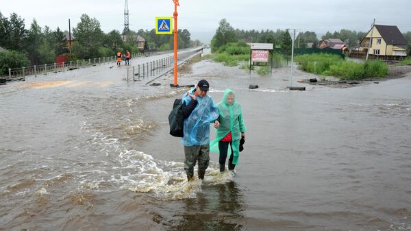 Местные жители на затопленной в результате паводка улице в Чите Местные жители на затопленной в результате паводка улице в Чите