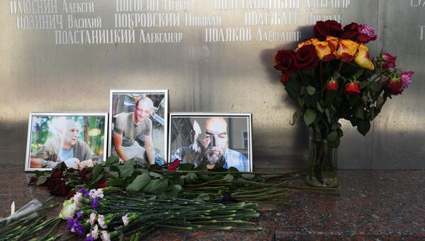 Цветы у фотографий погибших в Центральноафриканской Республике российских журналистов. Архивное фото Цветы у фотографий погибших в Центральноафриканской Республике российских журналистов. Архивное фото