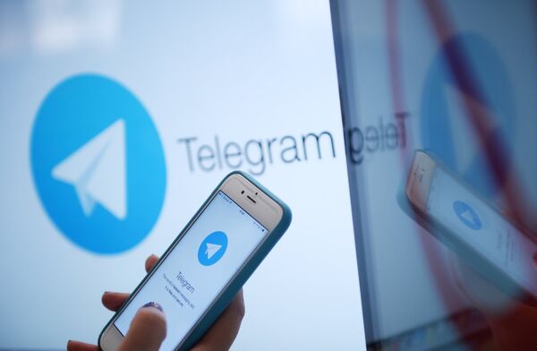 Логотип мессенджера Telegram на экране монитора и телефона Логотип мессенджера Telegram на экране монитора и телефона