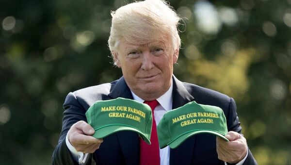 Президент США Дональд Трамп демонстрирует кепки с надписью Сделаем наших фермеров снова великими. Вашингтон, США