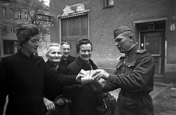 Советский солдат раздает хлеб женщинам Берлина. 7 мая 1945 Советский солдат раздает хлеб женщинам Берлина. 7 мая 1945