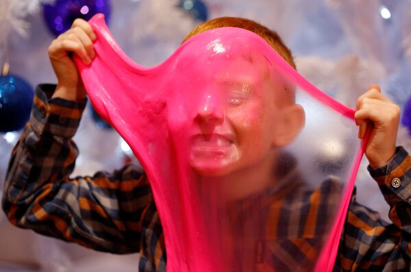 Мальчик играет Elasti Plasti во время старта продаж рождественских игрушек Hamleys в Лондоне Мальчик играет Elasti Plasti во время старта продаж рождественских игрушек Hamleys в Лондоне