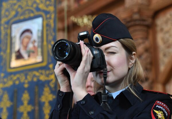 Сотрудник полиции фотографирует во время Божественной литургии в кафедральном соборе Успения Пресвятой Богородицы в Астрахане Сотрудник полиции фотографирует во время Божественной литургии в кафедральном соборе Успения Пресвятой Богородицы в Астрахане