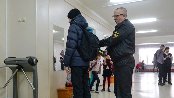 Сотрудник службы безопасности проверяет ученика в средней общеобразовательной школе Сотрудник службы безопасности проверяет ученика в средней общеобразовательной школе