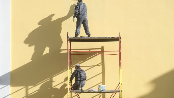 Рабочие красят фасад здания на одной из улиц Москвы Рабочие красят фасад здания на одной из улиц Москвы