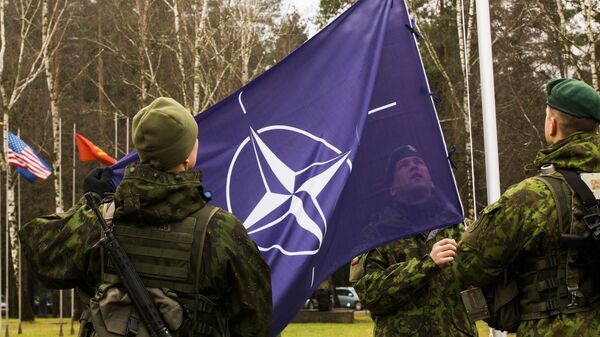 Военнослужащие поднимают флаг НАТО Военнослужащие поднимают флаг НАТО