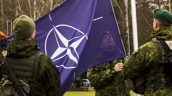 Военнослужащие поднимают флаг НАТО