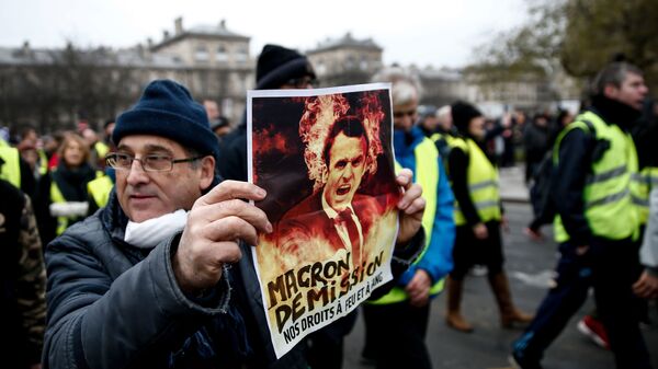 Демонстрант держит плакат во время акции желтых жилетов во Франции Демонстрант держит плакат во время акции желтых жилетов во Франции