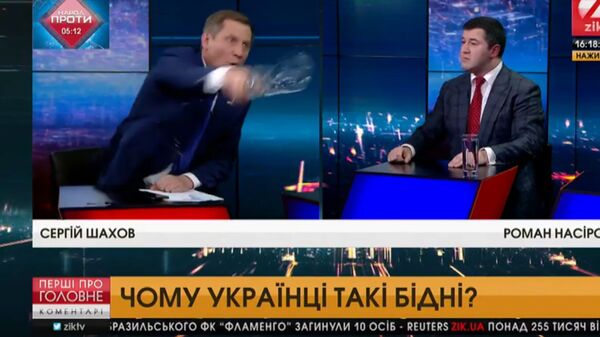 Скриншот видео, где депутат от группы Воля народа Сергей Шахов выплеснул стакан воды в сторону оппонента, экс-главы Государственной фискальной службы Украины Романа Насирова Скриншот видео, где депутат от группы Воля народа Сергей Шахов выплеснул стакан воды в сторону оппонента, экс-главы Государственной фискальной службы Украины Романа Насирова