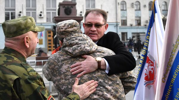 Люди поздравляют друг друга с 5-й годовщиной Общекрымского референдума 2014 года и воссоединения Крыма с Россией на одной из улиц в Симферополе