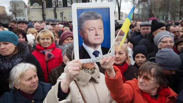 Люди слушают предвыборную речь президента Украины Петра Порошенко на Михайловской площади в Киеве