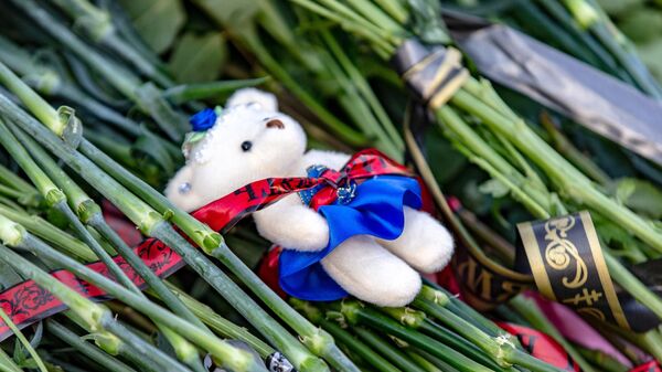 Цветы и мягкие игрушки у мемориала в память о жертвах пожара в торгово-развлекательном центре Зимняя вишня в Кемерово