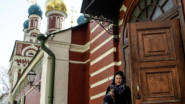 Женщина у храма Успения Пресвятой Богородицы в Гончарах в Москве