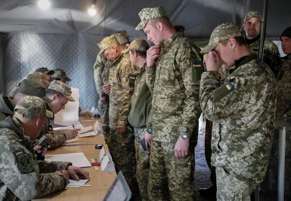 Украинские военнослужащие во время голосования на одном из избирательных участков в Донецкой области в день второго тура выборов президента Украины Украинские военнослужащие во время голосования на одном из избирательных участков в Донецкой области в день второго тура выборов президента Украины