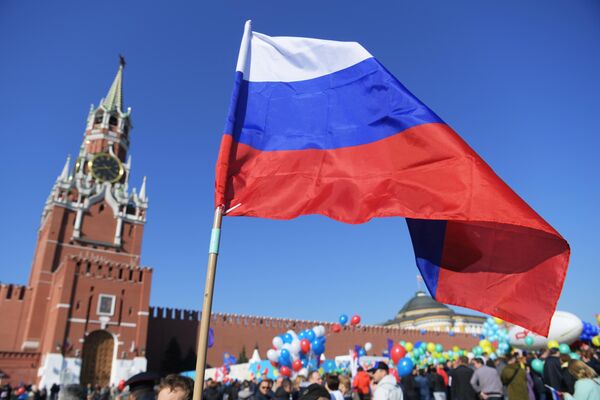 Российский флаг в руках одного из участников первомайской демонстрации столичных профсоюзов на Красной площади Российский флаг в руках одного из участников первомайской демонстрации столичных профсоюзов на Красной площади