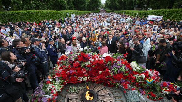 Участники акции Бессмертный полк возлагают цветы к Вечному огню в киевском парке Славы Участники акции Бессмертный полк возлагают цветы к Вечному огню в киевском парке Славы