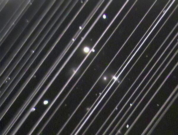 Фотография группы галактик NGC 5353/4 в созвездии Гончих Псов. Светлые линии на снимке – спутники системы Starlink Фотография группы галактик NGC 5353/4 в созвездии Гончих Псов. Светлые линии на снимке – спутники системы Starlink