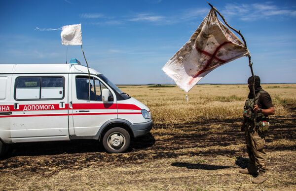 Украинский военный с белым флагом во время передачи убитых на нейтральной территории вблизи поселка Диброво возле российско-украинской границы в Донецкой области Украинский военный с белым флагом во время передачи убитых на нейтральной территории вблизи поселка Диброво возле российско-украинской границы в Донецкой области