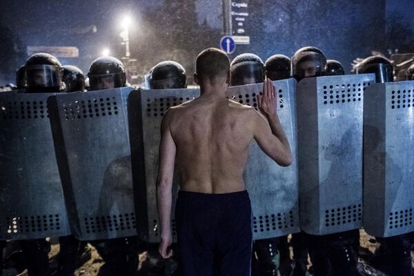 Участник акции протеста разговаривает с сотрудниками спецподразделения милиции Беркут на улице Грушевского в Киеве Участник акции протеста разговаривает с сотрудниками спецподразделения милиции Беркут на улице Грушевского в Киеве