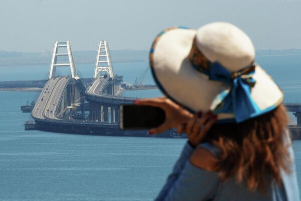 Девушка фотографирует Крымский мост через Керченский пролив