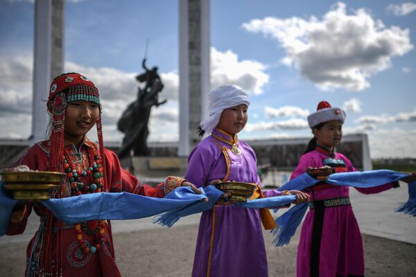 Девочки в национальных костюмах возле Мемориала, посвященного монгольским революционерам и героям войны, в городе Чойбалсан