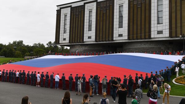 Участники флешмоба развернули государственный флаг Российской Федерации на площади Парка Победы на Поклонной горе в рамках празднования Дня государственного флага России Участники флешмоба развернули государственный флаг Российской Федерации на площади Парка Победы на Поклонной горе в рамках празднования Дня государственного флага России
