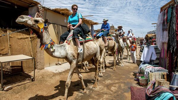 Туристы на верблюдах в деревне Гарб-Сахель в районе Асуана в Египте