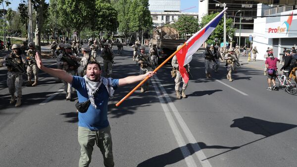 Протестующий во время акции протеста в Сантьяго Протестующий во время акции протеста в Сантьяго