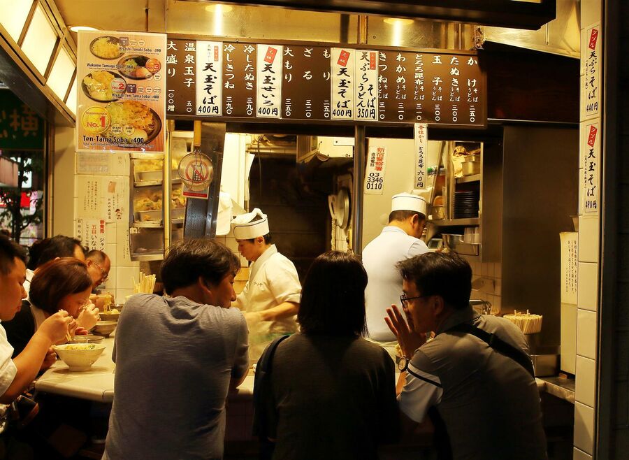 Посетители в закусочной в районе Синдзюку. Токио, Япония