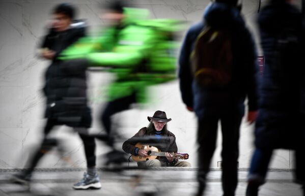 Уличный музыкант Сергей Садов выступает у входа в метро в Москве Уличный музыкант Сергей Садов выступает у входа в метро в Москве