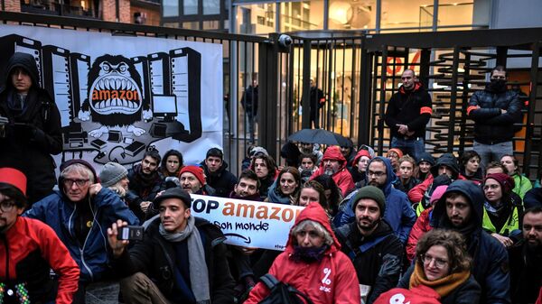 Активисты движения Attac во время акции против чрезмерного потребления перед штаб-квартирой Amazon во Франции. 29 ноября 2019 Активисты движения Attac во время акции против чрезмерного потребления перед штаб-квартирой Amazon во Франции. 29 ноября 2019