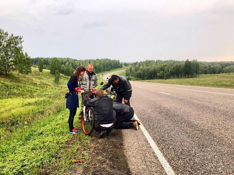 В дороге с ремонтом велосипеда помогают мотоциклисты В дороге с ремонтом велосипеда помогают мотоциклисты