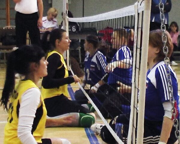 Спортсмены с ограниченными возможностями играют в волейбол сидя Спортсмены с ограниченными возможностями играют в волейбол сидя