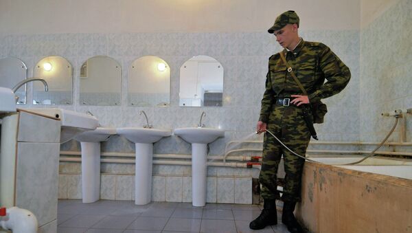 Солдат убирается в комнате для умывания. Архивное фото Солдат убирается в комнате для умывания. Архивное фото