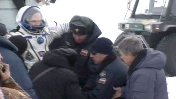 Прибывших с МКС космонавтов вынесли на руках из капсулы и закутали в пледы Прибывших с МКС космонавтов вынесли на руках из капсулы и закутали в пледы