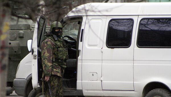 Сотрудник правоохранительных органов у автомобиля во время спецоперации по уничтожению боевиков. Архивное фото Сотрудник правоохранительных органов у автомобиля во время спецоперации по уничтожению боевиков. Архивное фото