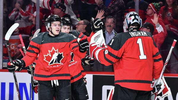 Хоккеисты молодежной сборной Канады Митчелл Стивенс (слева) и Коннор Ингрэм радуются заброшенной шайбе